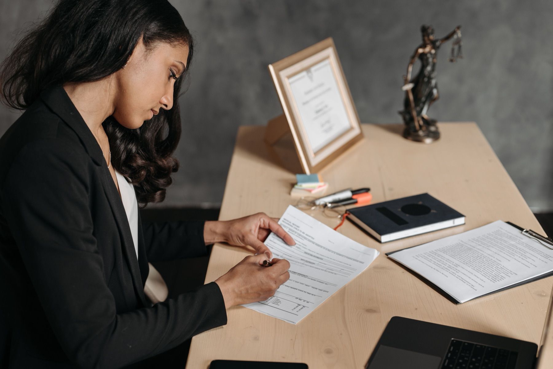 Solicitor reviewing and signing legal documents at her desk