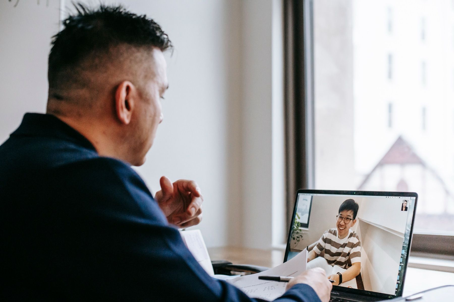 Professional on a video call with a client on a laptop